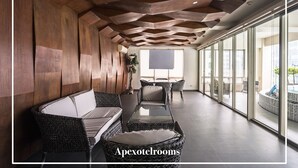 Un espace de détente moderne avec un plafond en bois, des sièges confortables et de grandes fenêtres offrant une vue sur la ville.