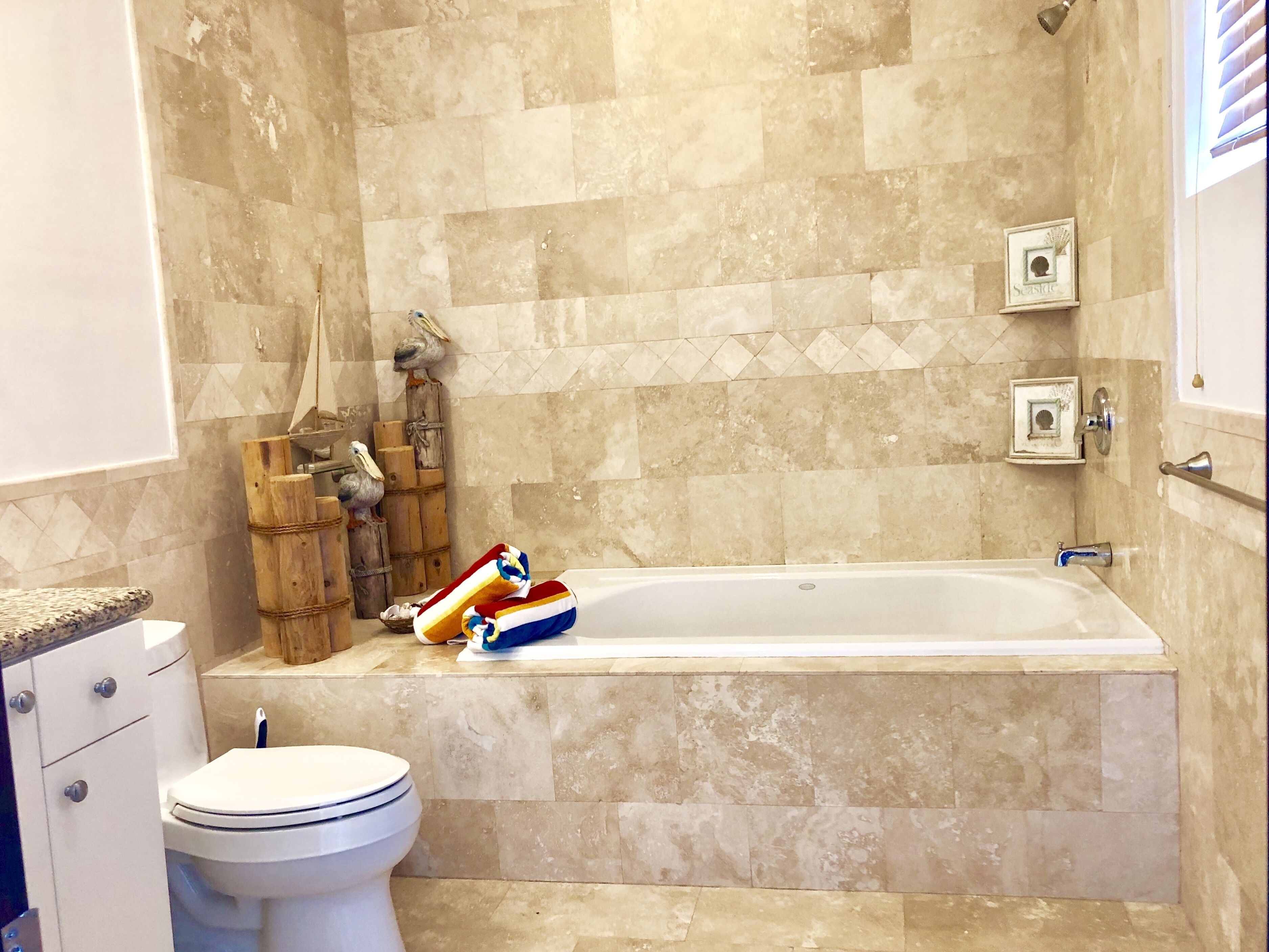 Un baño con bañera, inodoro y zona de ducha.