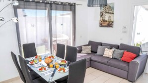 Een eethoek met een tafel voor vier personen, een bank en een balkon met uitzicht.