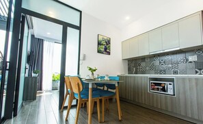 Enjoy meals in this stylish kitchen and dining area, featuring a microwave and a table with comfortable seating.