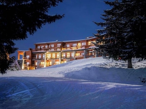 Experience the warmth of this mountain hotel, set amidst a serene winter landscape with breathtaking views from balconies.