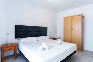 Une chambre d’hôtel comprenant un lit, une table de chevet, un bureau, une armoire et une lampe.