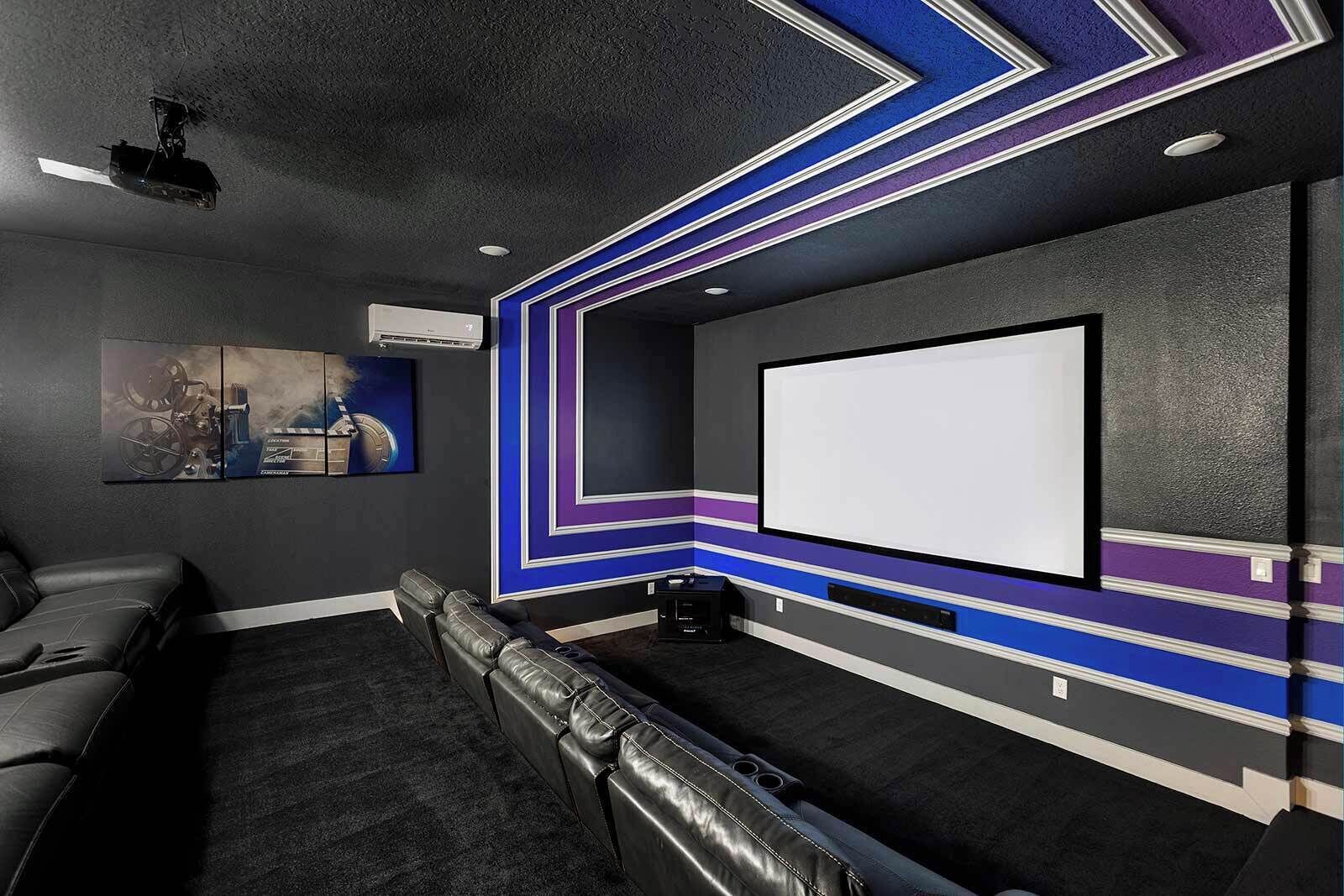A home theater room with a large screen, comfortable seating, and a projector.