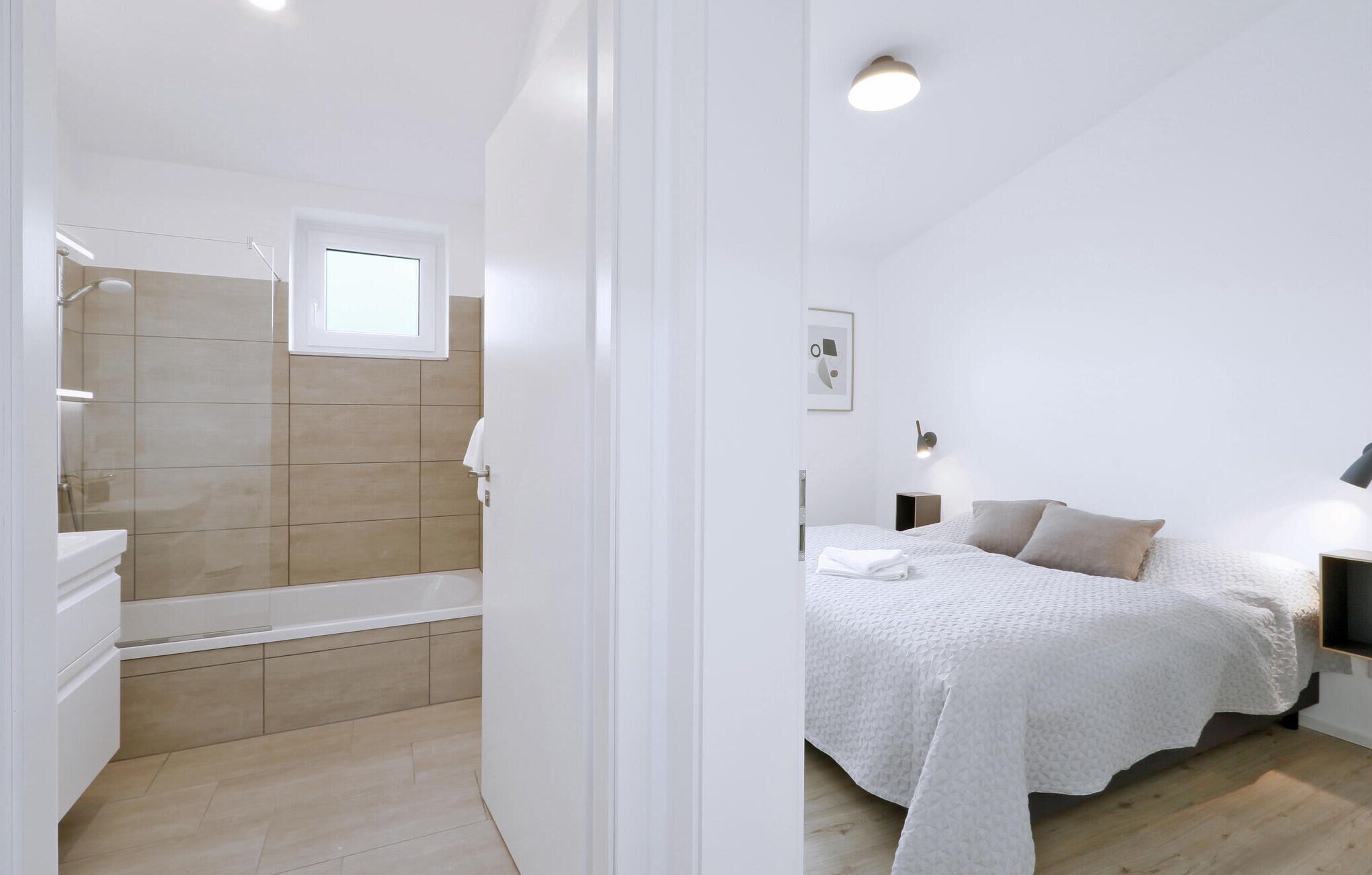 A bedroom with a bed, bedside tables, and a nightstand.