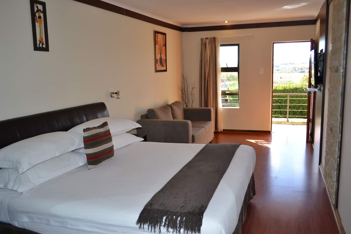 Une chambre d’hôtel avec un grand lit, un canapé et une télévision.