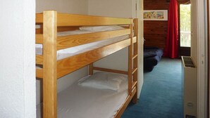 A bunk bed room with a blue carpet, a wooden door, and a window with red curtains. - Comfortable Studio 4 Pers, Near Station and Chairlift, Les Orres (Les Orres)