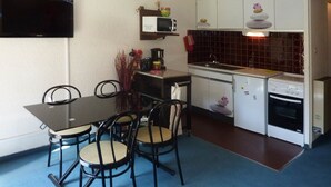 A compact kitchen with a dining table, chairs, a microwave, a sink, and a stove. - Comfortable Studio 4 Pers, Near Station and Chairlift, Les Orres (Les Orres)