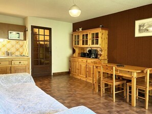 A compact kitchen with wooden cabinets, a built-in microwave, and a coffee maker.