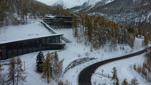 A modern building with large windows, surrounded by snow-covered trees and mountains. - Cozy studio 5 pers, direct slope access, southwest balcony (Les Orres)