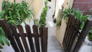 Un estrecho callejón con una puerta de madera que da a un edificio.