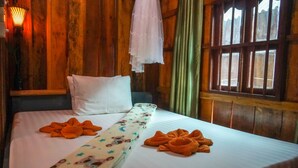 A neatly made bed with white linens and orange towels arranged on it. - Green Ocean Koh Rong (Koh Rong)