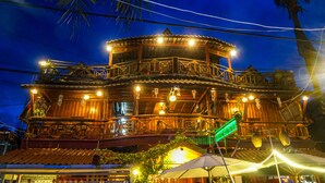 A multi-story building with a wooden facade, balconies, and outdoor seating areas. - Green Ocean Koh Rong (Koh Rong)