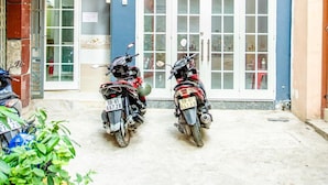 A building with a blue facade, a red flag, and two motorcycles parked in front. - Saigon House 18Bis (Ho Chi Minh City)