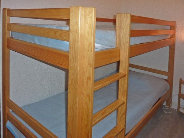 A bunk bed with wooden frames and blue bedding. - Garden-Level Studio for 4 with Ski-In/Ski-Out Access and SW Terrace (Les Orres)