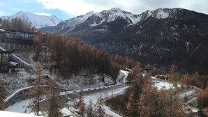 A mountain resort with a road leading to a building with large windows. - Newly Renovated Studio for 2 in Central Location with Direct Slope Access, Balcony & Stunning Views (Les Orres)
