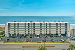 Hotel offers a scenic view of the nearby water from its modern design with flat roof and balconies.