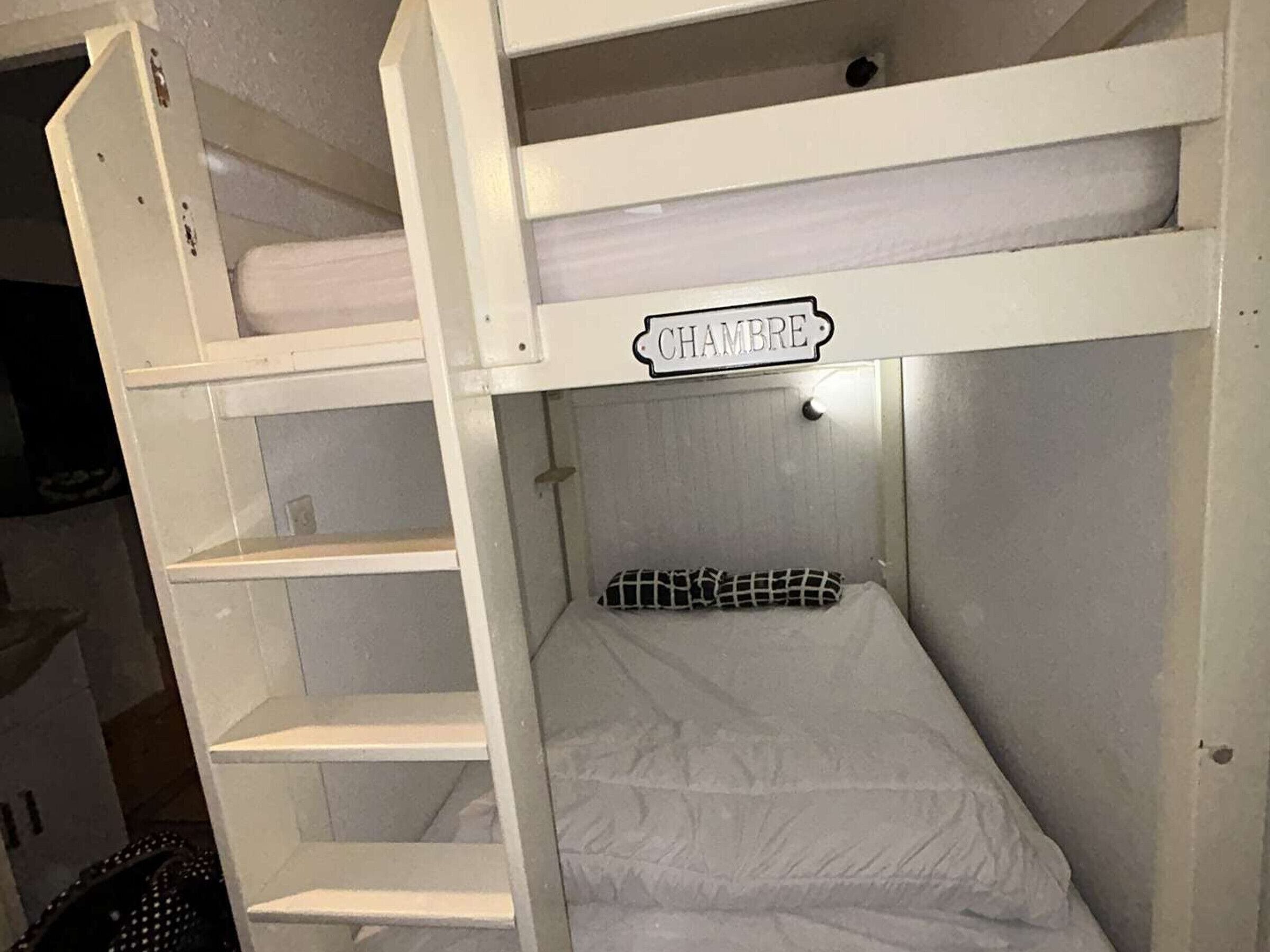Ein Etagenbett mit der Aufschrift 'CHAMBRE', das einen schlicht eingerichteten, funktionalen Raum kennzeichnet.