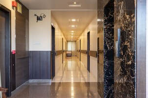 Ein Hotelkorridor mit Marmorwand, Holzvertäfelung und Decken mit eingelassener Beleuchtung.