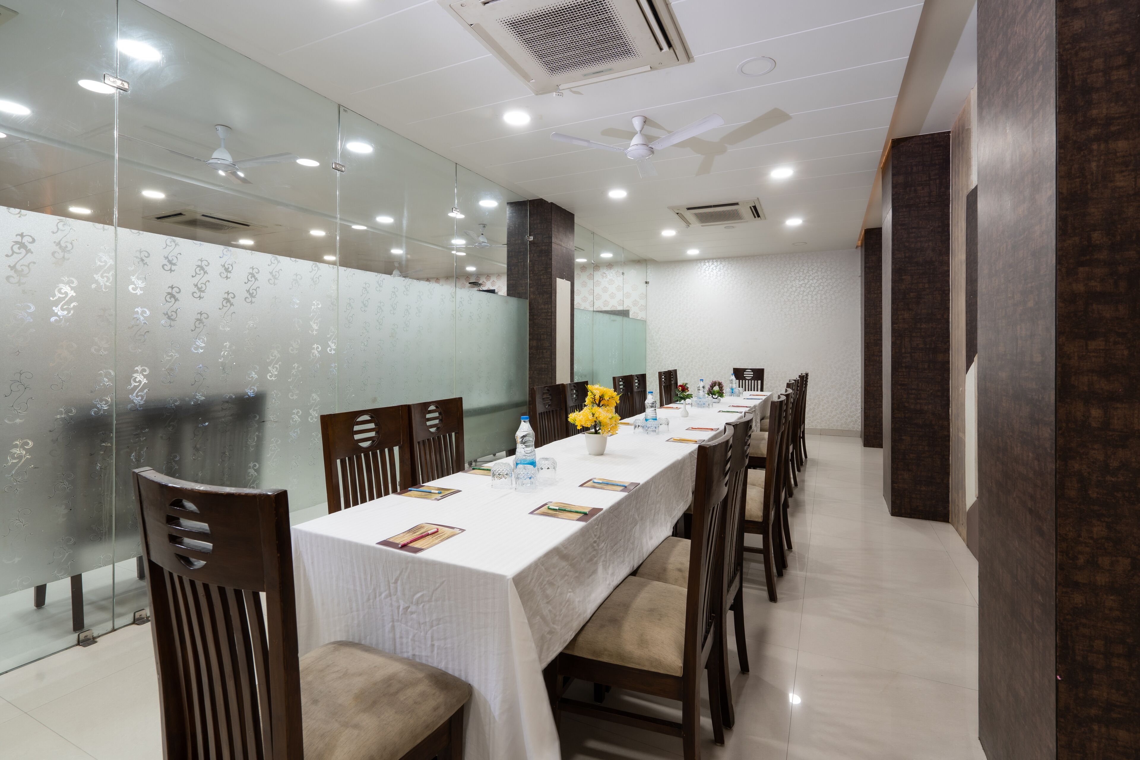 A conference room with a long table, chairs, and a white tablecloth.