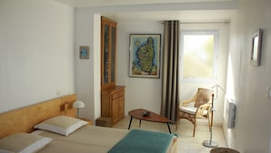 A hotel room with a bed, a small table, a chair, a cabinet, a painting, and a window. - rental in the gulf of valinco in Propriano (Propriano)