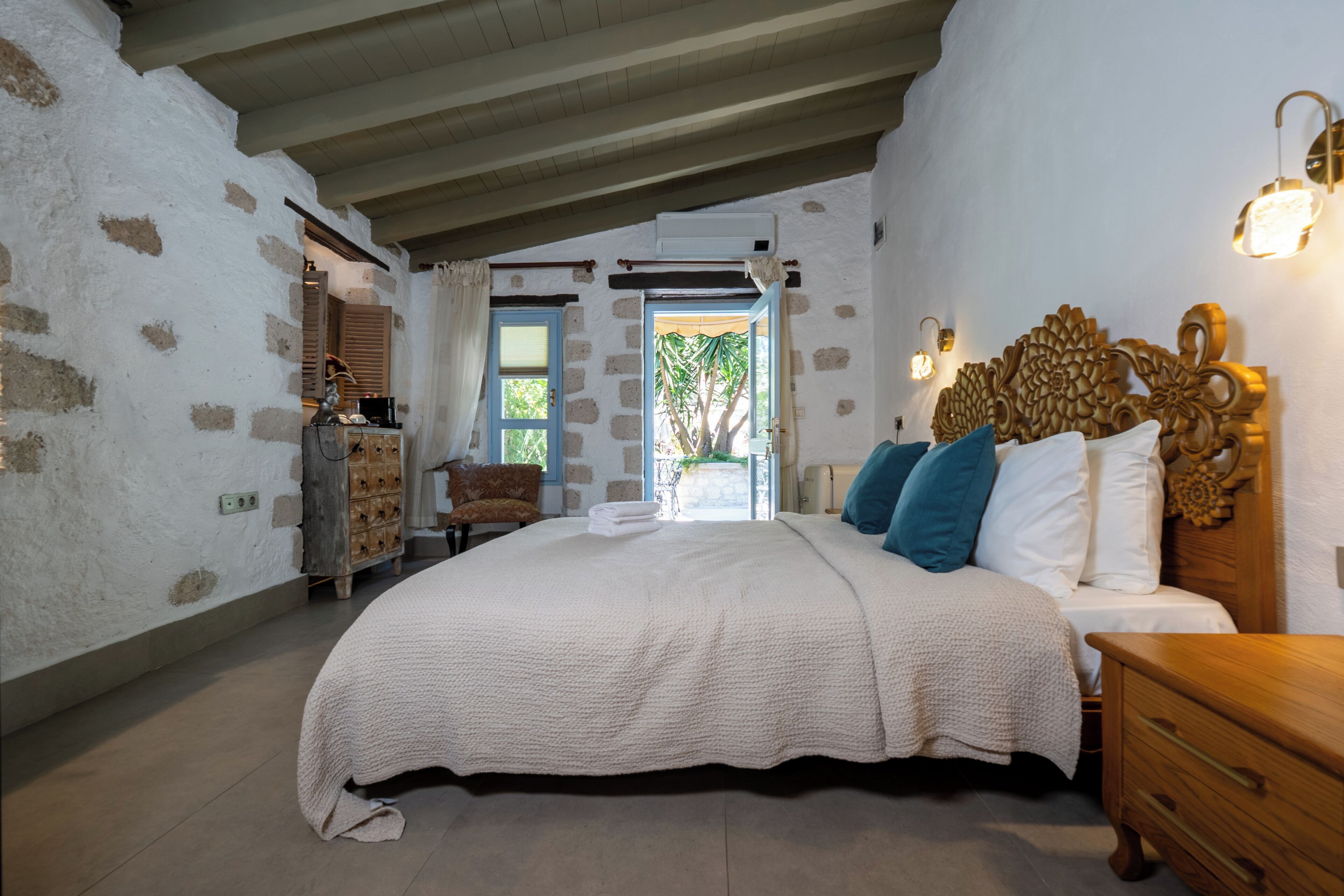 Un dormitorio con cama, cabecero de madera, mesita de noche y cómoda.