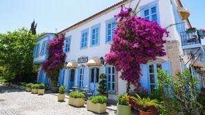A building with blue shutters and a sign reading "TAS OTEL". - Tas Otel (Cesme)