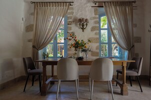 Un comedor con una mesa de madera, cuatro sillas y un florero.