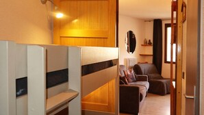 Ein Zimmer mit Etagenbetten, einer Schlafcouch und einem kleinen Tisch.