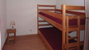 A bunk bed room with a small bedside table and a lamp. - Cozy studio, ski-in/ski-out, central location, sleeps 6, south-facing balcony (Les Orres)