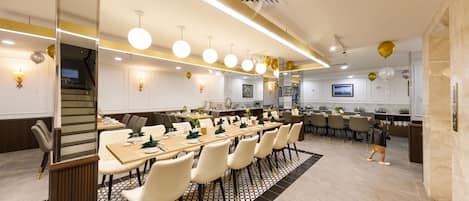 A modern conference room with a long table, white chairs, and a patterned rug.