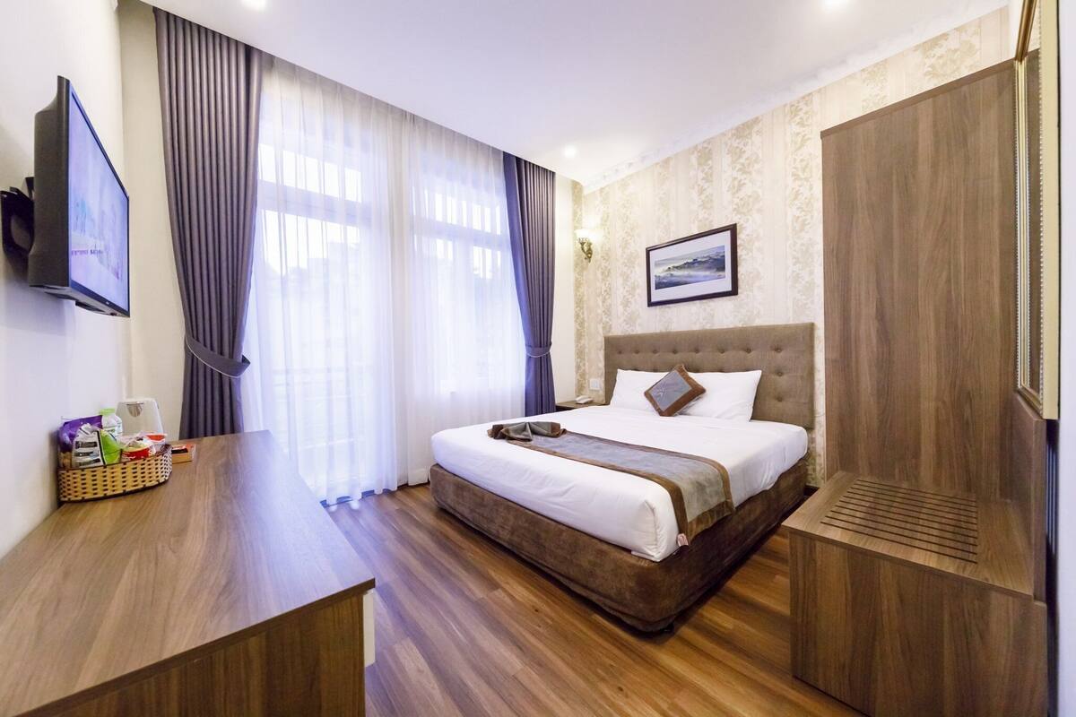 Une chambre d’hôtel équipée d’un lit, d’une télévision, d’un bureau et d’une armoire.