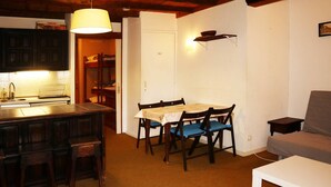 A compact living space with a kitchen, dining area, and seating area. - Family studio 4 pers, ski-in/ski-out, near center (Les Orres)