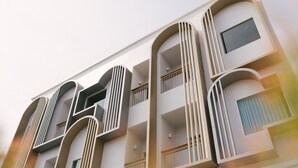 A multi-story building with balconies, large windows, and a modern architectural design. - Nappiness Hotel (Bangkok)