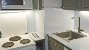 A compact kitchen with a stove, microwave, sink, and dishwasher.