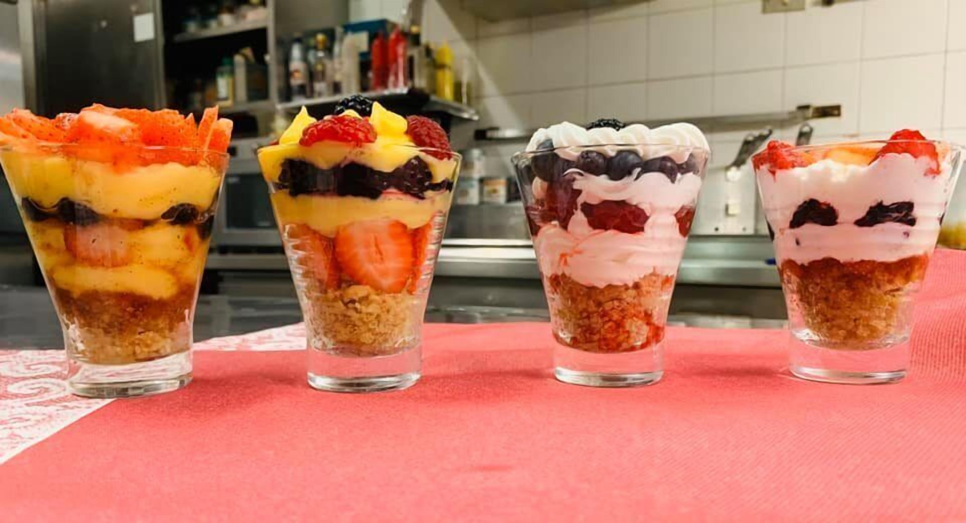 Cuatro copas de postre en una mesa.