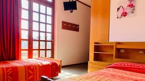 A bedroom with two single beds, a wooden headboard, a TV mounted on the wall, and a window with red curtains. - La Scardola Ristorante Hotel Bar (Baselga di Pine)