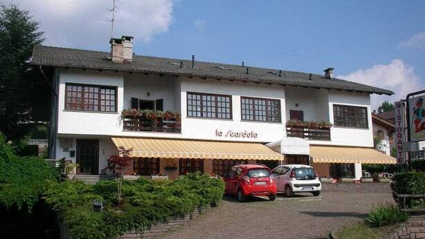 A two-story building with a sign reading "La Giarda." There are two cars parked in front, and the building has a balcony with potted plants. - La Scardola Ristorante Hotel Bar (Baselga di Pine)