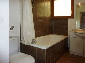 Ein Badezimmer mit Badewanne, Toilette und Waschbecken.