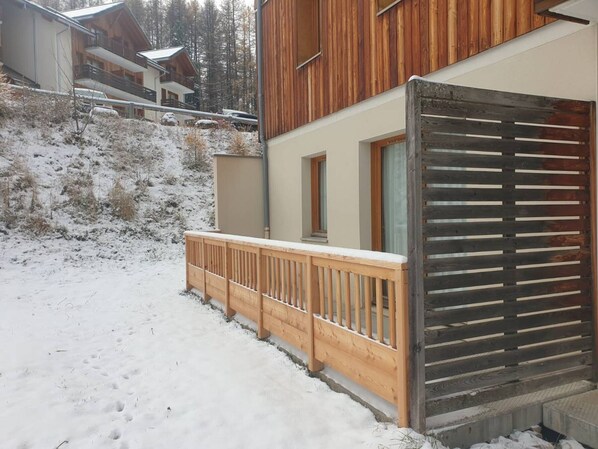 A wooden cabin with a balcony, surrounded by snow-covered ground and trees. - Spacious 3-Room Apartment for 8 with Heated Pool & Terrace in Les Orres 1800 (Les Orres)