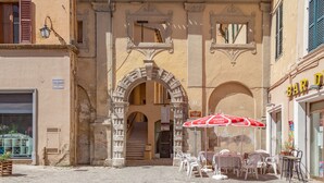 An outdoor café with outdoor seating and a staircase leading to an upper level. - Dimora Storica Lo Svevo (Jesi)