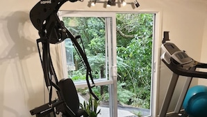 A home gym with an elliptical, a treadmill, and a bench. - Tui2 - Studio (Macandrew Bay)