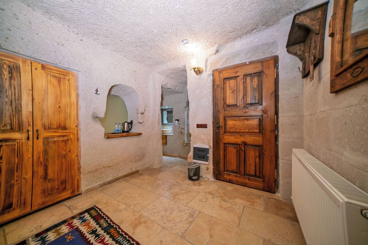 A hallway with wooden doors, a radiator, and a tiled floor.