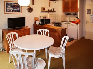 A compact kitchen with a dining area, featuring a TV, a coffee maker, and a microwave. - Cozy Studio Central Location, Ski-In/Ski-Out, Sleeps 4, South-Facing Balcony (Les Orres)