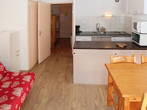 A compact kitchen with a dining area, a microwave, a coffee maker, and a sink.