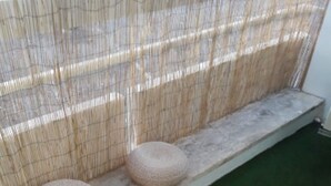 A round table with a woven base and a white top, placed on a green artificial turf. - ScandiChic De La Gare Studio (Arles)