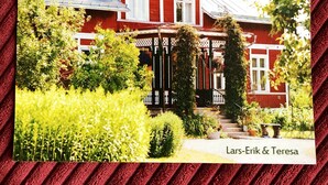 A red house with a porch, surrounded by greenery. - 2-bed Apartment Overlooking the River (Avesta)