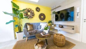 Un salon moderne avec un canap é, une table basse et des œuvres d’art décoratives au mur.