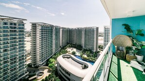 Un immeuble résidentiel de grande hauteur doté de nombreux balcons, d’une piscine sur le toit et d’une cour aménagée.