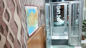 Ingresso di un hotel con un muro decorato, una mappa e vasi in metallo a parete.
