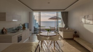 Una sala de estar moderna con vista al mar, un comedor y una cocina.